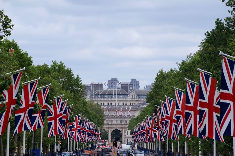 Union Jack flags line The Mall in London leading up to Admiralty Arch, showcasing British pride.